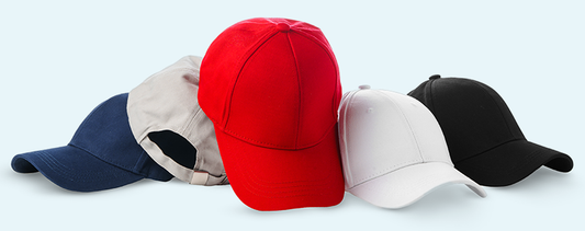 Five blank baseball caps in navy blue, beige, red, white, and black colors displayed in a row on a light background
