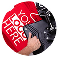 A hand holding a machine printing a red shirt with white logo