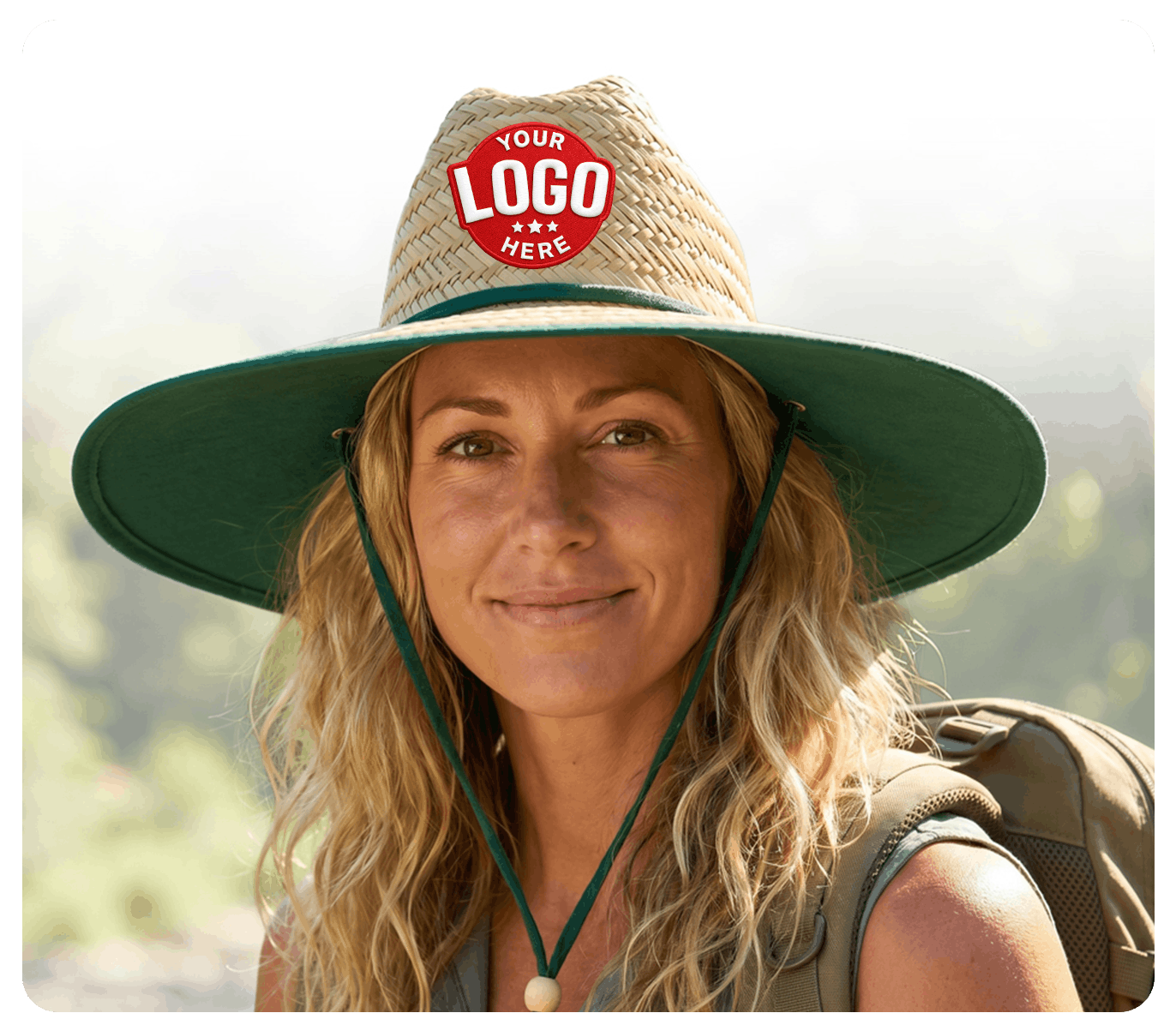 Woman wearing a straw hat with a logo placeholder, standing outdoors.